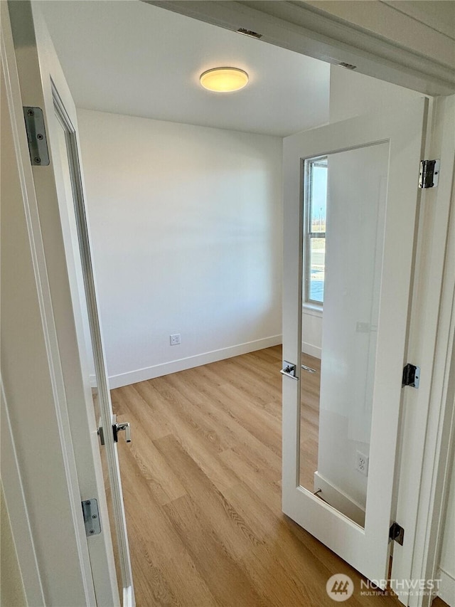 interior space featuring light wood-style flooring and baseboards