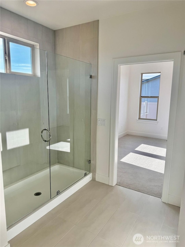 bathroom featuring baseboards, a shower stall, and tile patterned floors