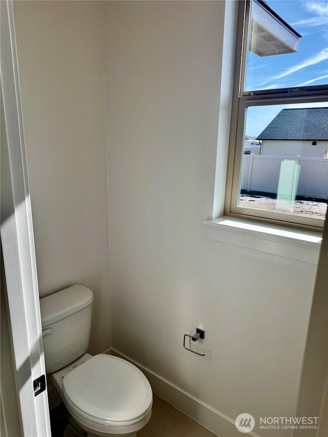 bathroom with toilet and baseboards