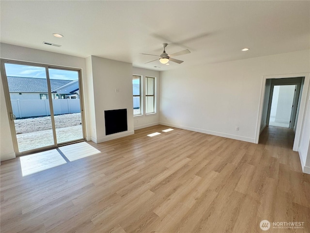 unfurnished living room featuring light wood finished floors, baseboards, visible vents, and a ceiling fan