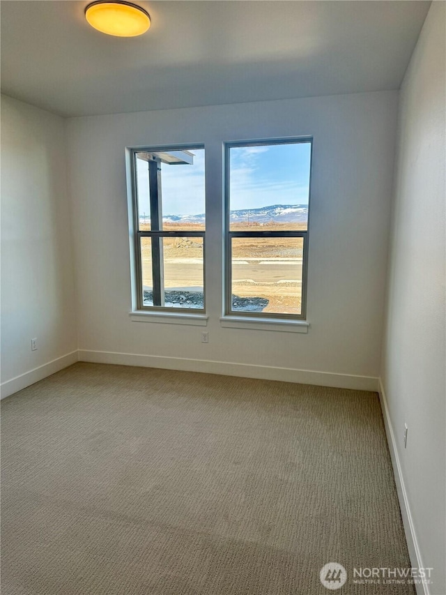 empty room featuring carpet floors and baseboards