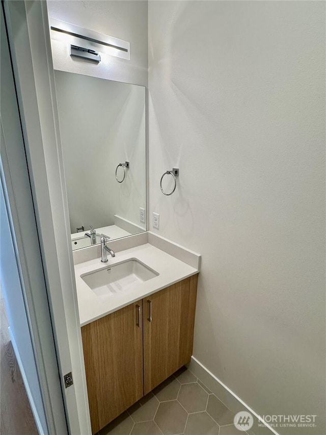 bathroom featuring tile patterned flooring, baseboards, and vanity