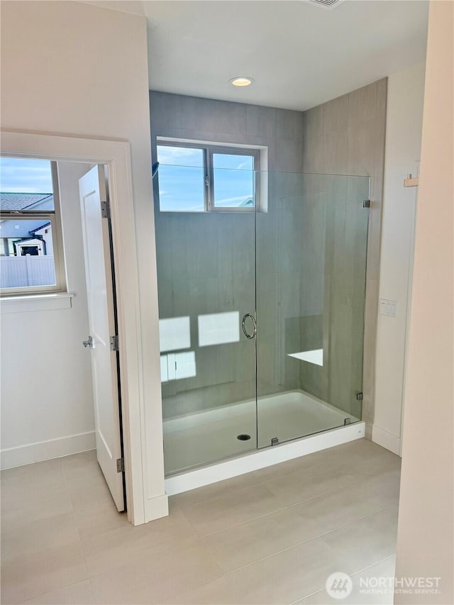 full bathroom with tile patterned floors, a shower stall, and baseboards