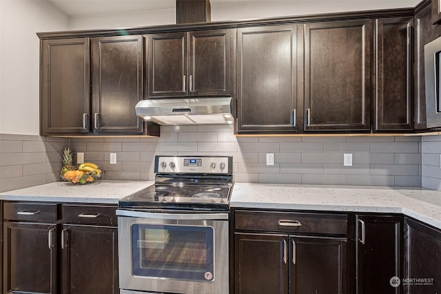 kitchen with light stone counters, dark brown cabinetry, stainless steel electric range oven, and backsplash