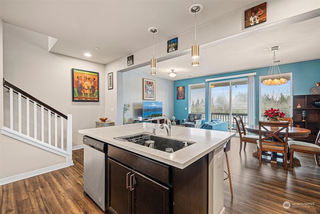 kitchen with stainless steel dishwasher, sink, decorative light fixtures, a center island with sink, and dark hardwood / wood-style floors