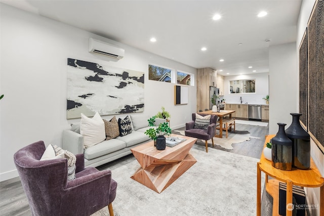 living room featuring wood-type flooring, an AC wall unit, and sink