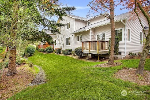 back of property featuring a yard and a wooden deck