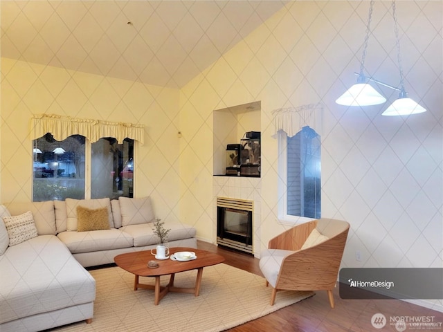 living room featuring a tiled fireplace and hardwood / wood-style flooring