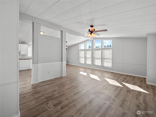 unfurnished living room with vaulted ceiling with beams, ceiling fan, and wood-type flooring