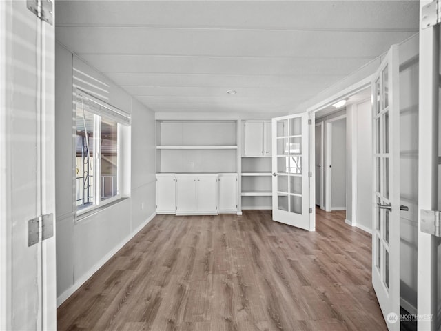 unfurnished living room featuring french doors and light hardwood / wood-style floors