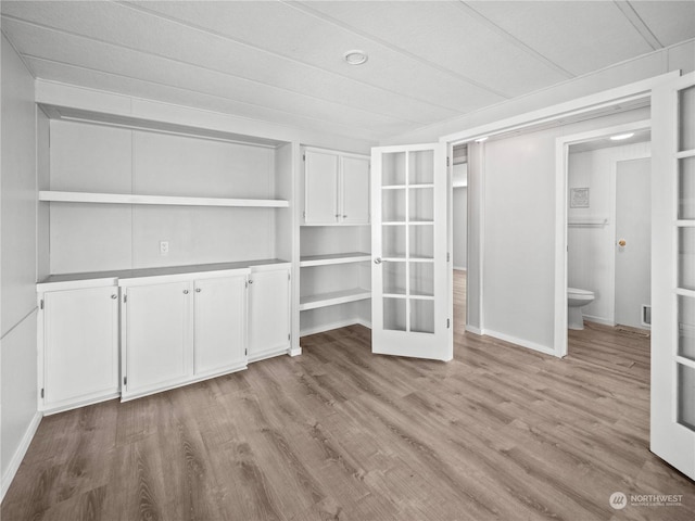 spacious closet featuring light hardwood / wood-style floors and french doors