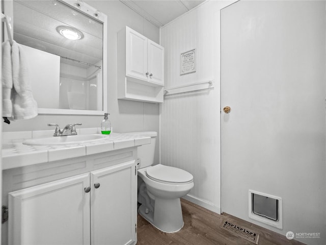 bathroom featuring toilet, vanity, and hardwood / wood-style flooring