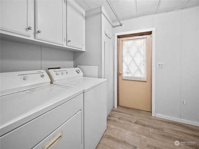 laundry area with independent washer and dryer, cabinets, and light wood-type flooring