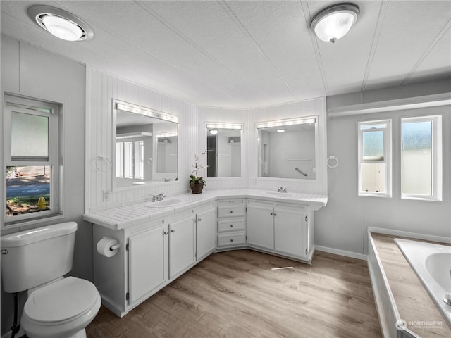 bathroom featuring a textured ceiling, vanity, hardwood / wood-style flooring, and toilet