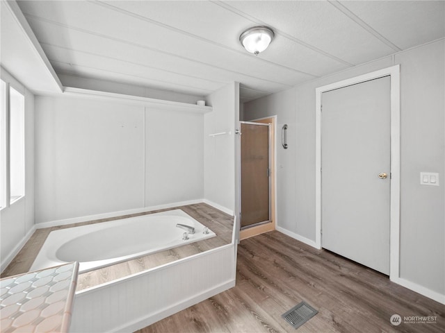 bathroom with hardwood / wood-style flooring and independent shower and bath