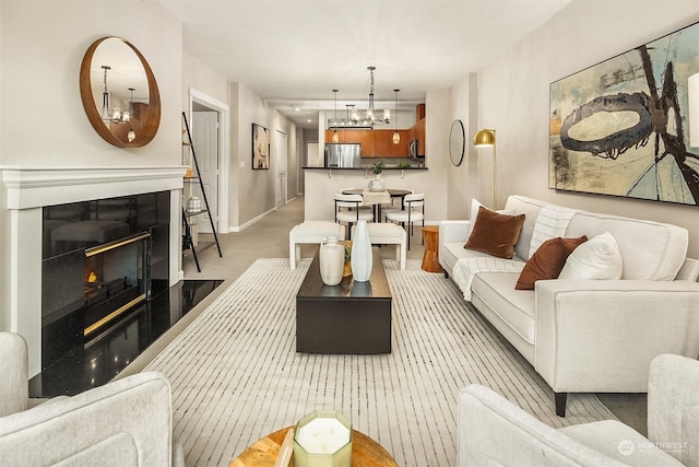 carpeted living room with an inviting chandelier