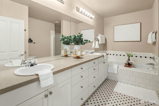 bathroom featuring tile patterned floors, vanity, a relaxing tiled tub, and toilet