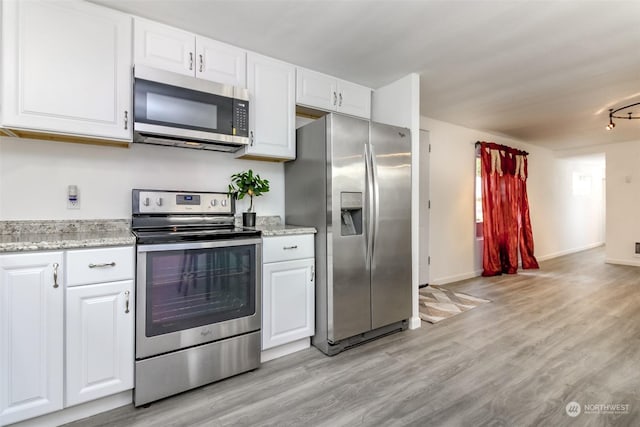 kitchen featuring white cabinets, appliances with stainless steel finishes, rail lighting, and light hardwood / wood-style floors