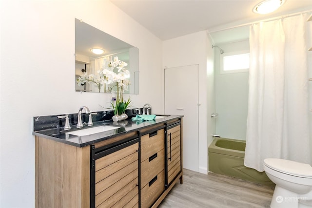 full bathroom with wood-type flooring, vanity, toilet, and shower / bath combo with shower curtain