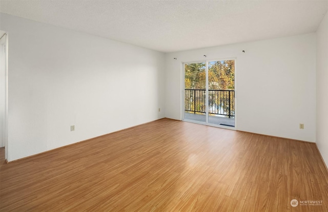 unfurnished room featuring a textured ceiling and light wood-type flooring