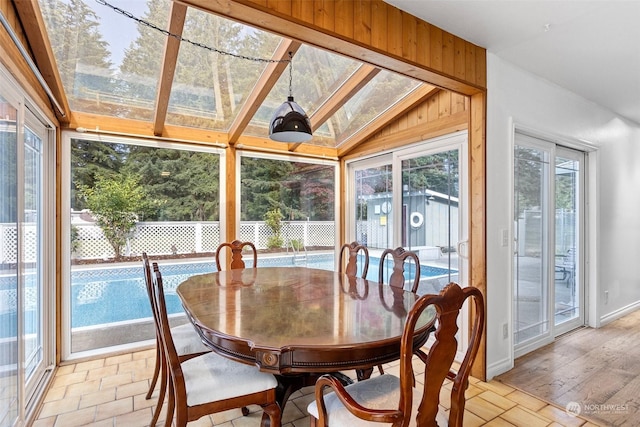 sunroom / solarium with a healthy amount of sunlight and vaulted ceiling with skylight