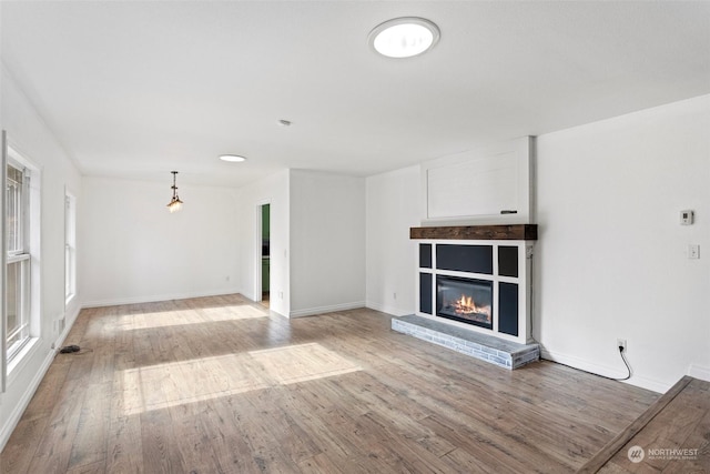 unfurnished living room with a fireplace and light hardwood / wood-style floors