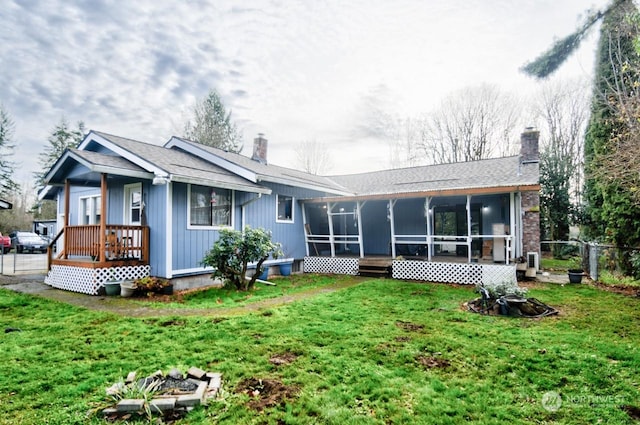 back of property featuring a sunroom and a yard