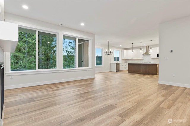 unfurnished living room featuring visible vents, baseboards, light wood-style floors, a chandelier, and recessed lighting