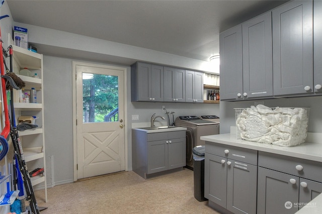 washroom with cabinets, light carpet, washer and clothes dryer, and sink