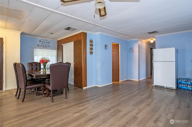 dining area featuring ceiling fan, ornamental molding, and hardwood / wood-style flooring