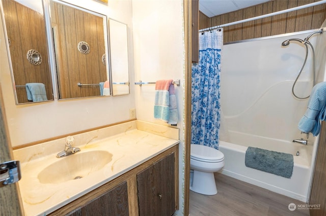 full bathroom featuring hardwood / wood-style floors, shower / bath combo, toilet, and vanity