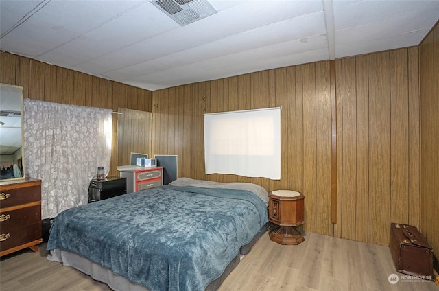 bedroom featuring hardwood / wood-style flooring and wooden walls