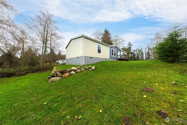 view of side of home with a yard and a deck