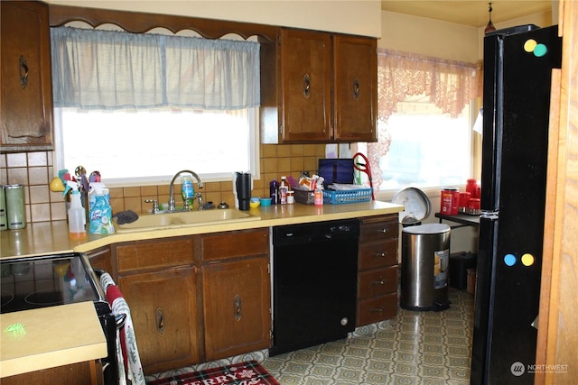 kitchen with black appliances, a healthy amount of sunlight, sink, and tasteful backsplash