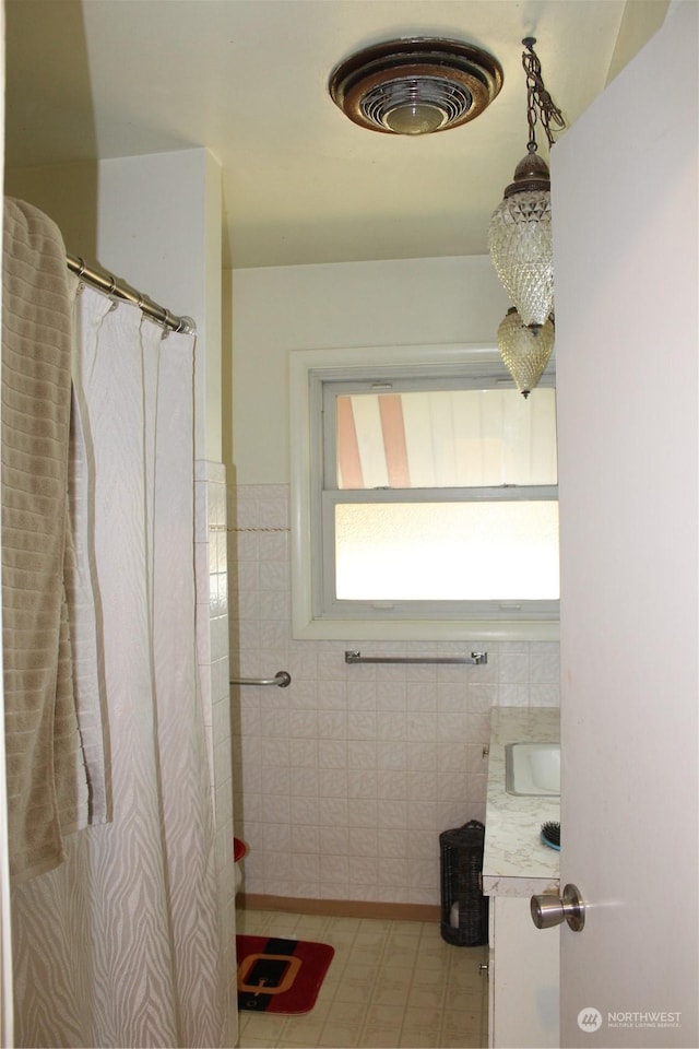 bathroom featuring tile walls and sink