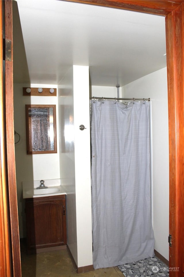 bathroom with curtained shower and vanity