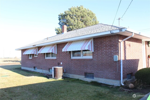 view of property exterior featuring central AC unit and a lawn