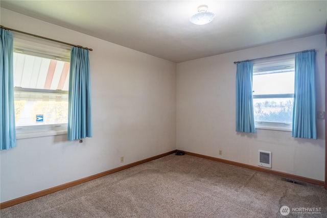 carpeted empty room featuring visible vents and baseboards