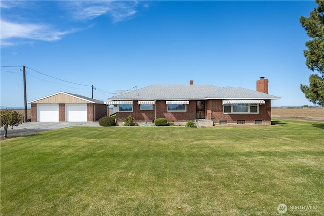 ranch-style home with an outbuilding, a chimney, a garage, brick siding, and a front yard