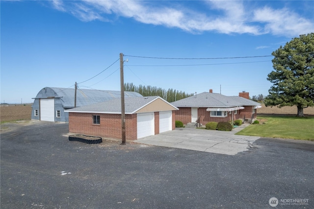 view of front of home featuring brick siding and a detached garage
