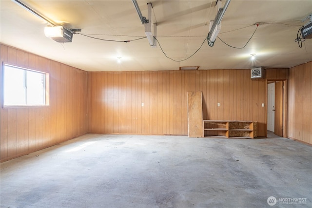 garage with wood walls and a garage door opener