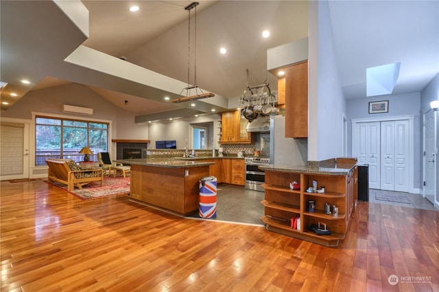 kitchen featuring kitchen peninsula, stainless steel range oven, and light wood-type flooring