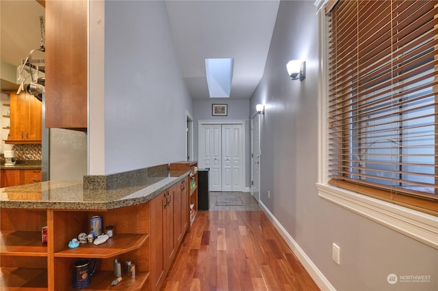 hall with hardwood / wood-style flooring and a skylight