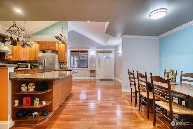 kitchen with stainless steel appliances, tasteful backsplash, light hardwood / wood-style flooring, lofted ceiling, and ornamental molding