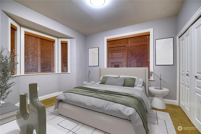 tiled bedroom featuring multiple windows and a closet