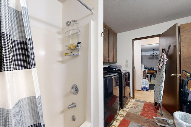 bathroom with shower / bath combo and a textured ceiling