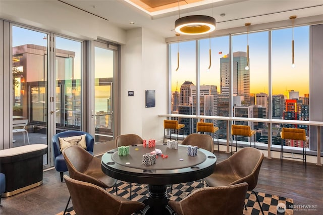 dining area with wood finished floors and a city view