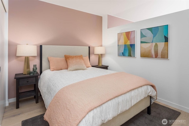 bedroom featuring baseboards and wood finished floors