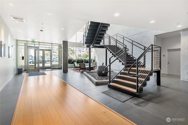 stairs featuring hardwood / wood-style floors, floor to ceiling windows, and french doors