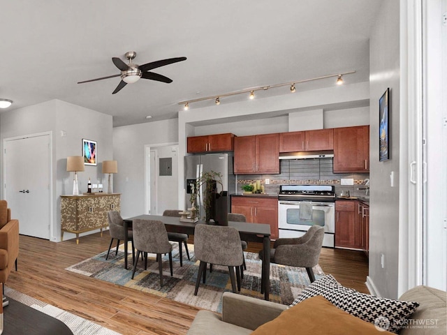 kitchen featuring dark countertops, dark wood-style floors, backsplash, and stainless steel appliances